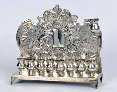 On both sides holders for removable items. One is for the shamash, the other for a removable decoration which is missing. Height: 30 cm, width: 23 cm, one oil font is missing.