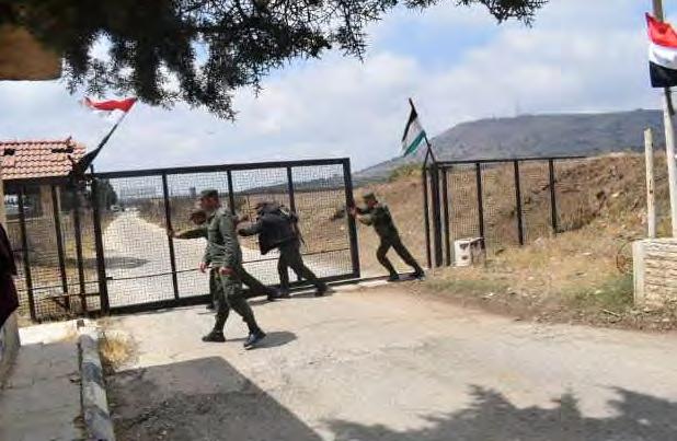 ל ו ת מ ש ר ד ההגנה הרוסי, 3 באוגוסט 2018 (. מימין : חיילי צבא סוריה פותחים את מעבר קניטרה, עליו מתנוסס דגל סוריה.