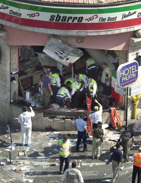 שוטרים וכוחות הצלה בזירת פיגוע ההתאבדות במסעדת סבארו ב- 9 לאוגוסט, 2001.